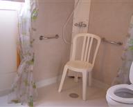 La salle d'eau : douche italienne, barres de soutien, toilettes rehaussés.